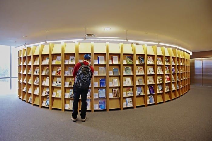 student browsing shelves of magazines in a library