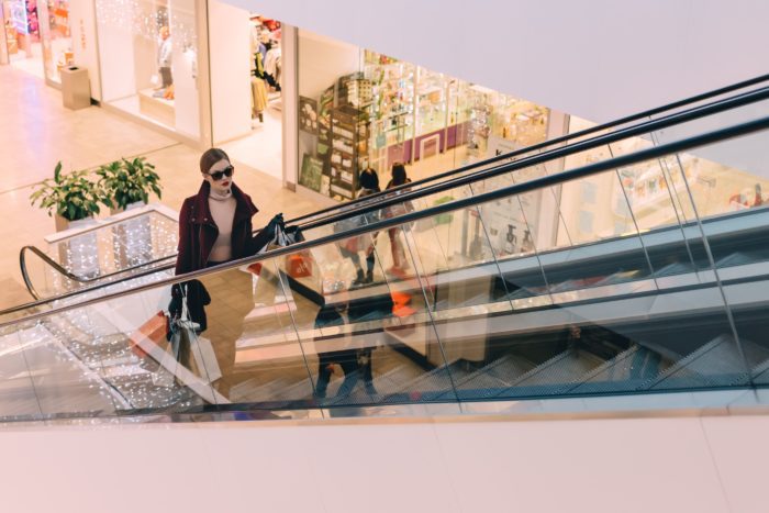 woman in shopping mall on escalator