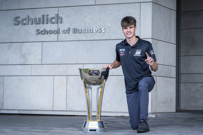 Treyten with trophy outside Schulich