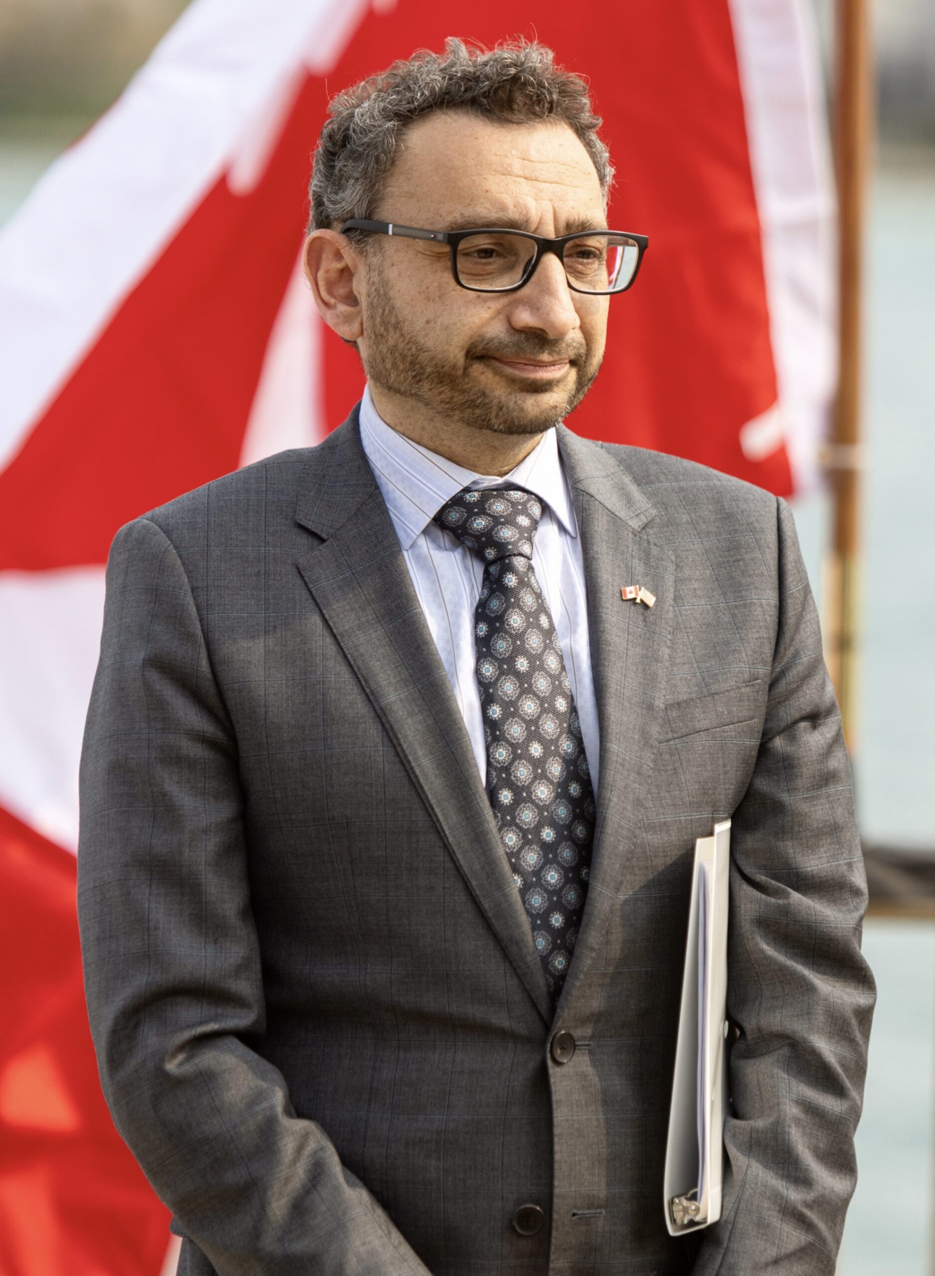 Omar Alghabra standing with a suit looking away from the camera