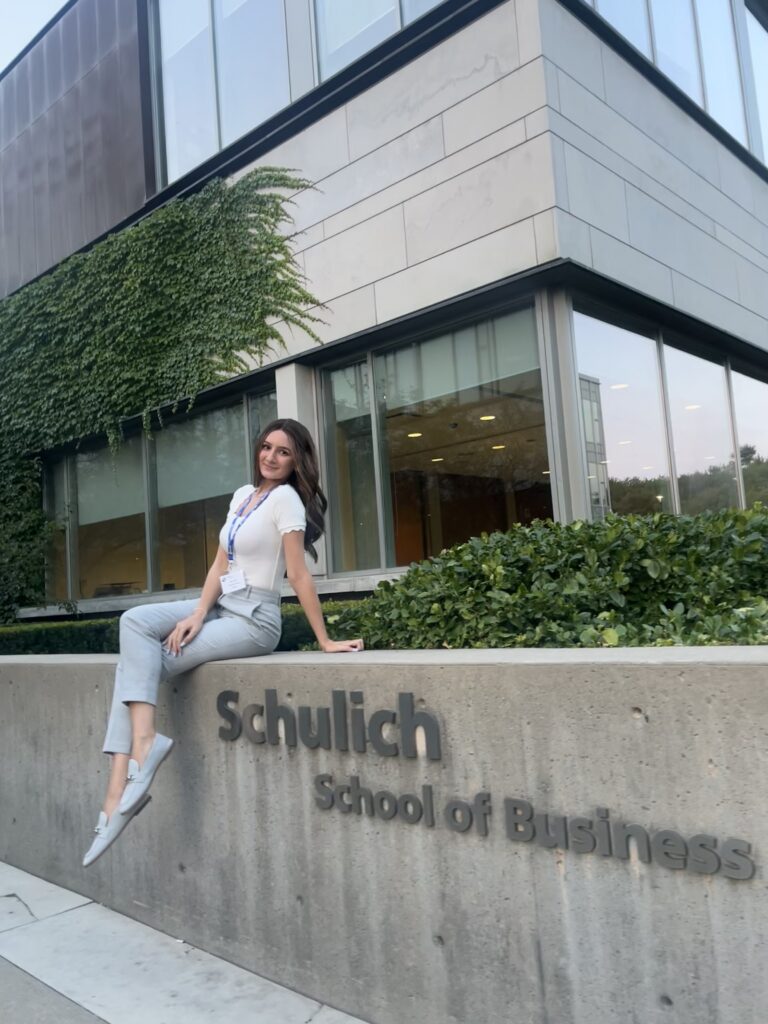 Young woman sitting outside the Schulich School of Business.