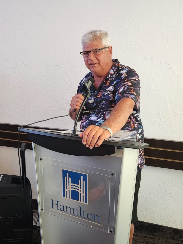 Man speaking into a microphone at a podium.